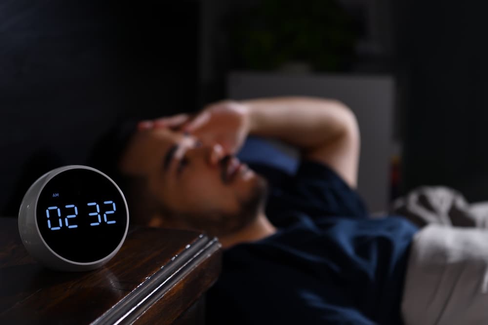 Man struggling to get to sleep