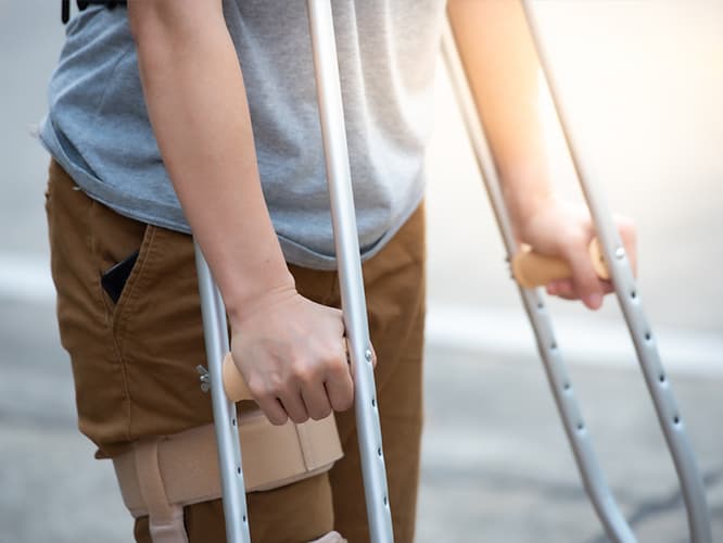 A pair of hands holding a pair of crutches