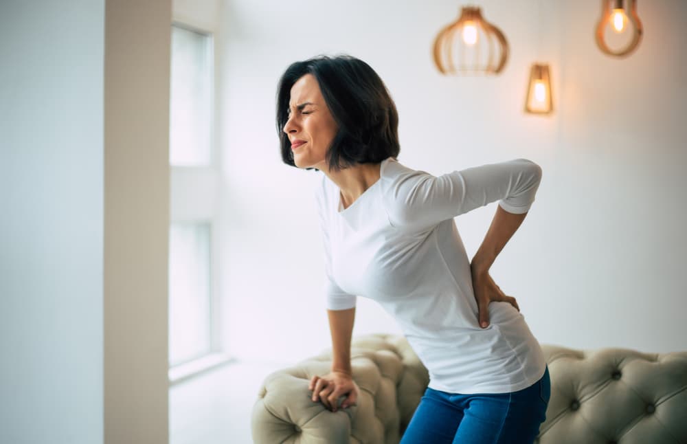 Lady desperately clutching her back due to back pain