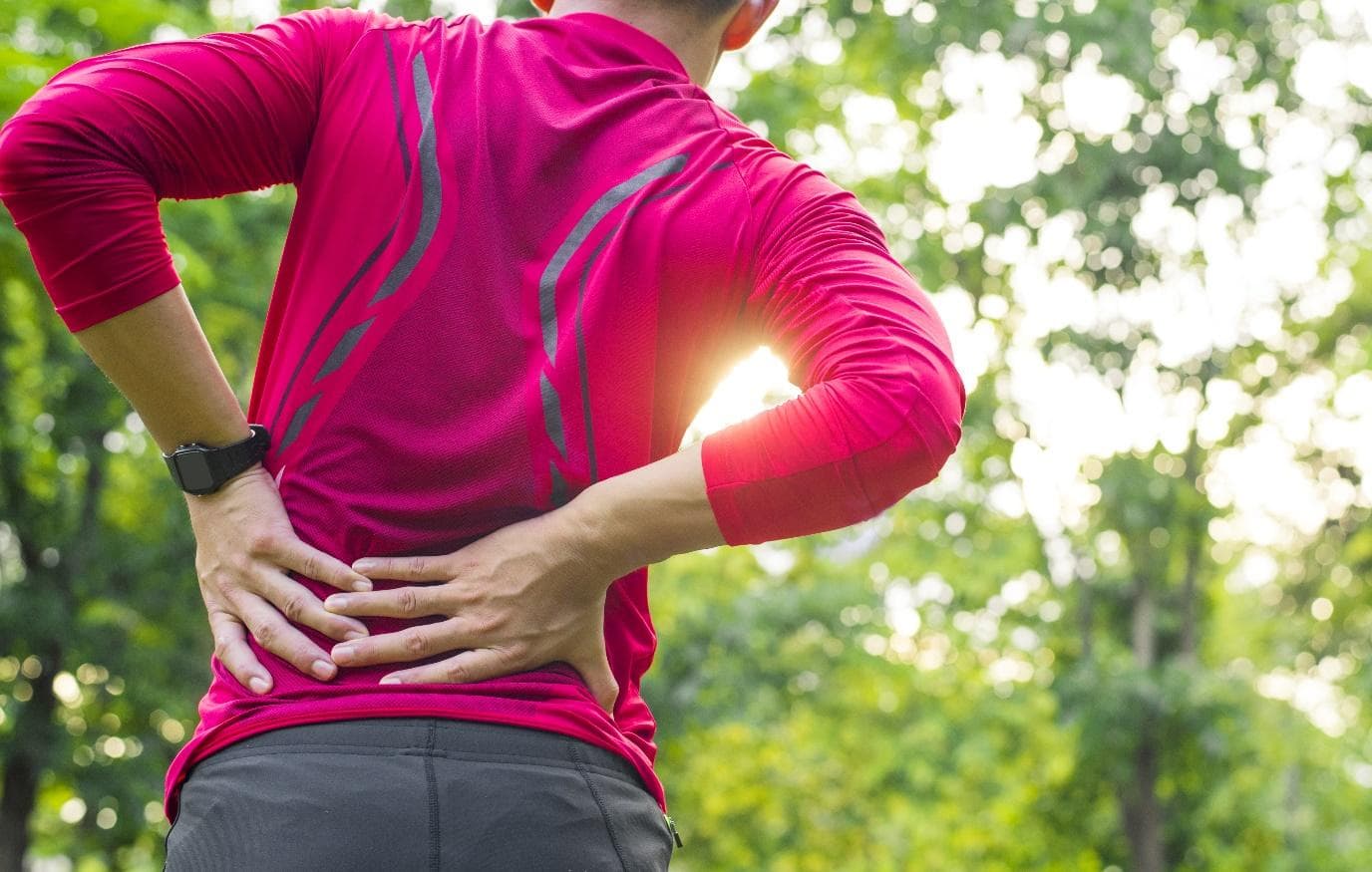 A man holding his back because of experiencing back pain