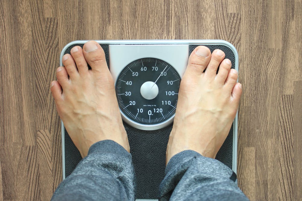 A pair of feet stood on a weighing scale to check their body weight